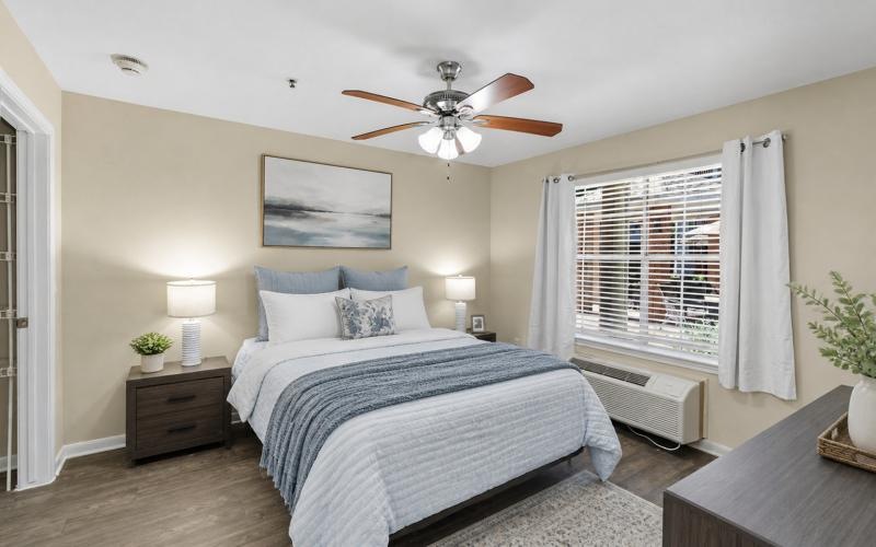 a bedroom with a fan and a bed