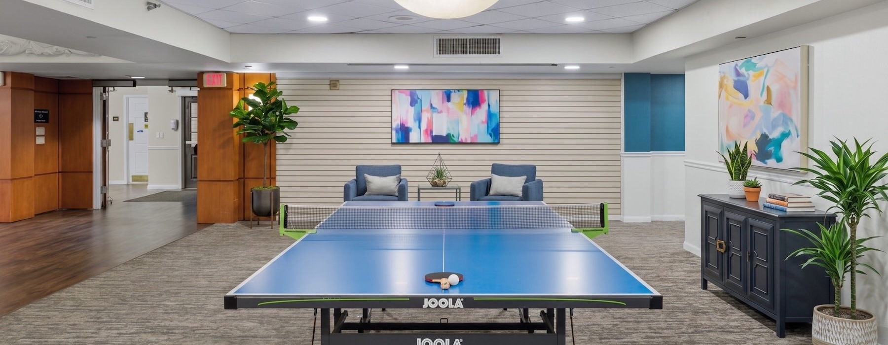 a room with a pool table and chairs